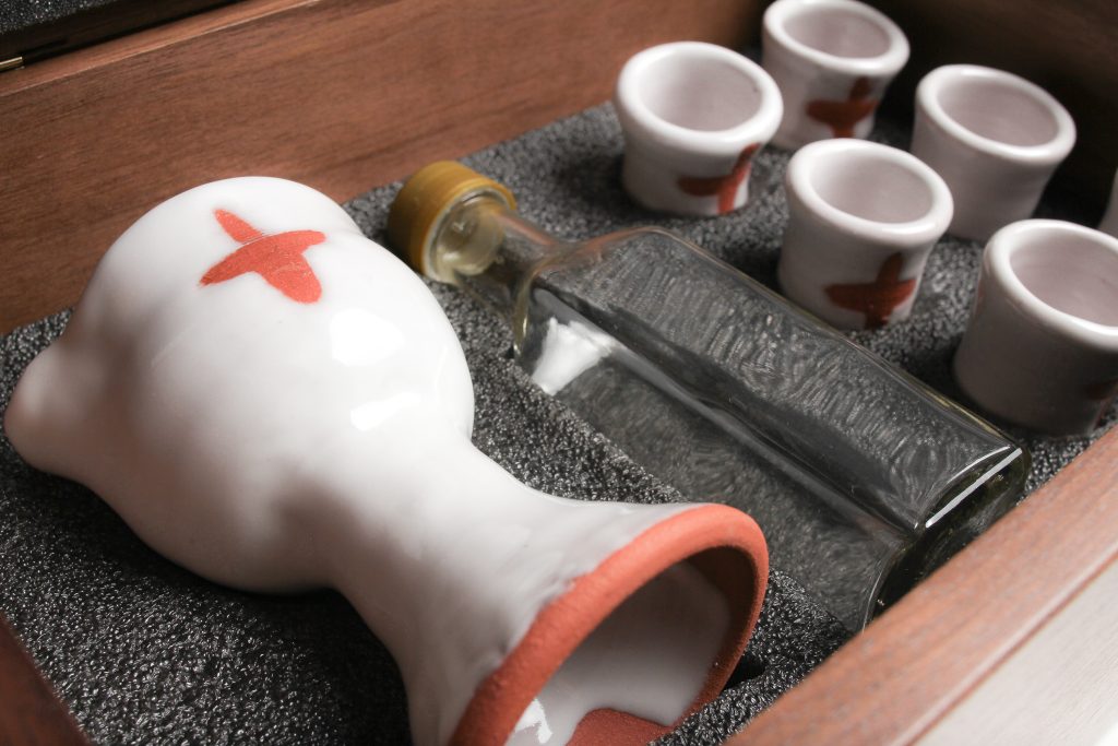 Glass wine bottle with spill proof cap (Glass is cleanable, and unlike the plastic ones you have used, glass will not stain over time). The glass bottle is dishwasher safe. If you do find a discoloration after many uses, swish a few grains of uncooked rice with a little water around in the bottle. They scrub it clean! Handwash the plastic lid.