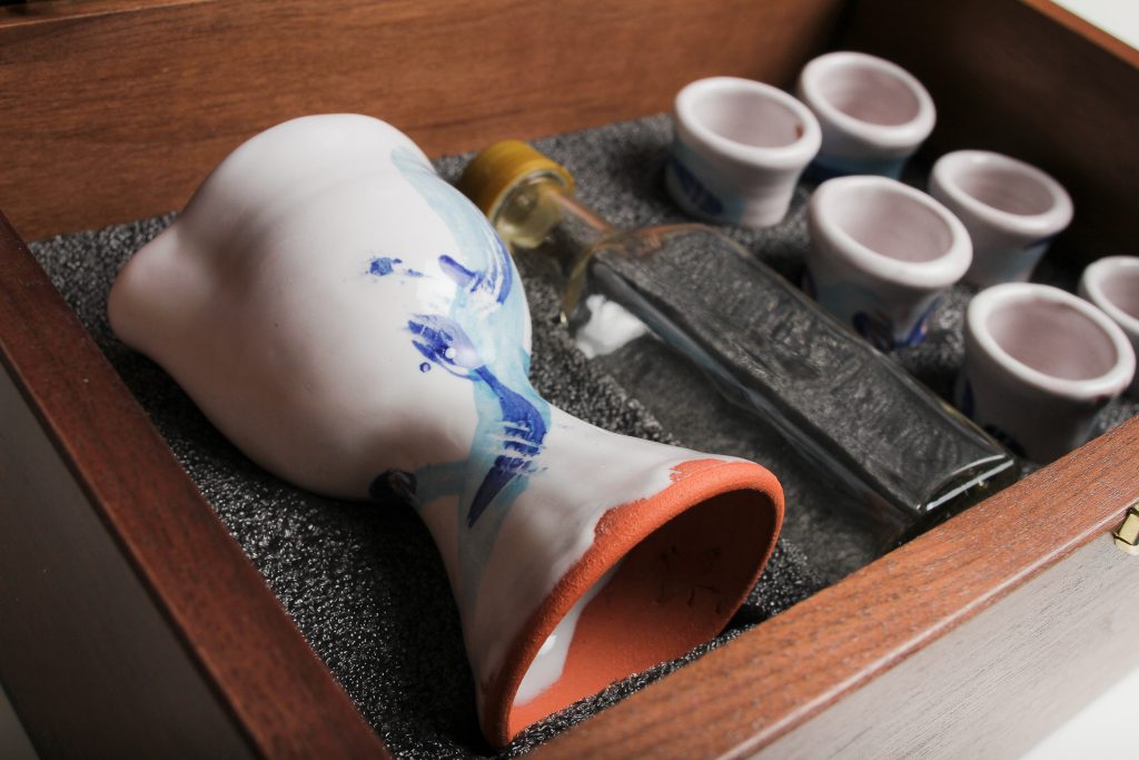 Glass wine bottle with spill proof cap (Glass is cleanable, and unlike the plastic ones you have used, glass will not stain over time). The glass bottle is dishwasher safe. If you do find a discoloration after many uses, swish a few grains of uncooked rice with a little water around in the bottle. They scrub it clean! Handwash the plastic lid.