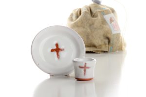 The set includes a cup, a paten, and a felt bag for transport and storage